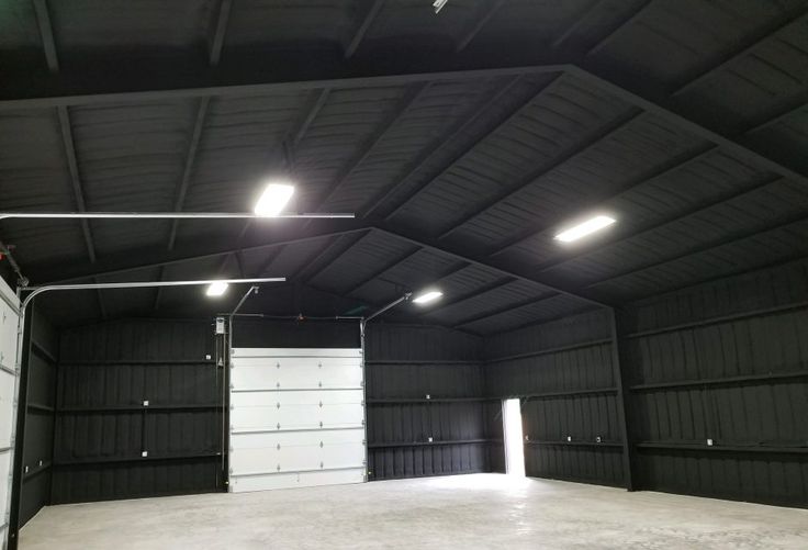 an empty garage with lights on the ceiling and doors open to let people know where they are going