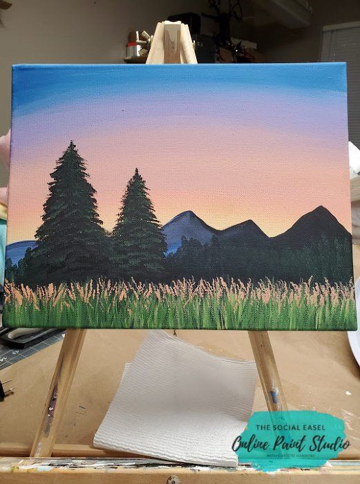 an acrylic painting of trees and mountains in the distance with watercolor paints on easel