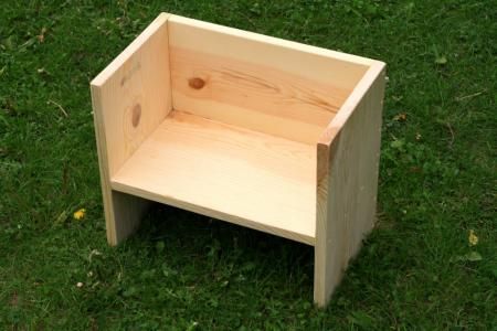 a wooden step stool sitting in the grass