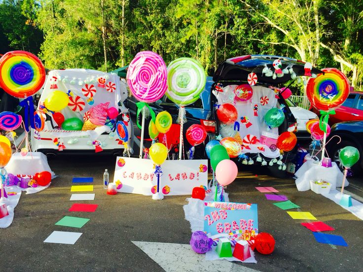 a car parked in front of a bunch of balloons and streamers on the road