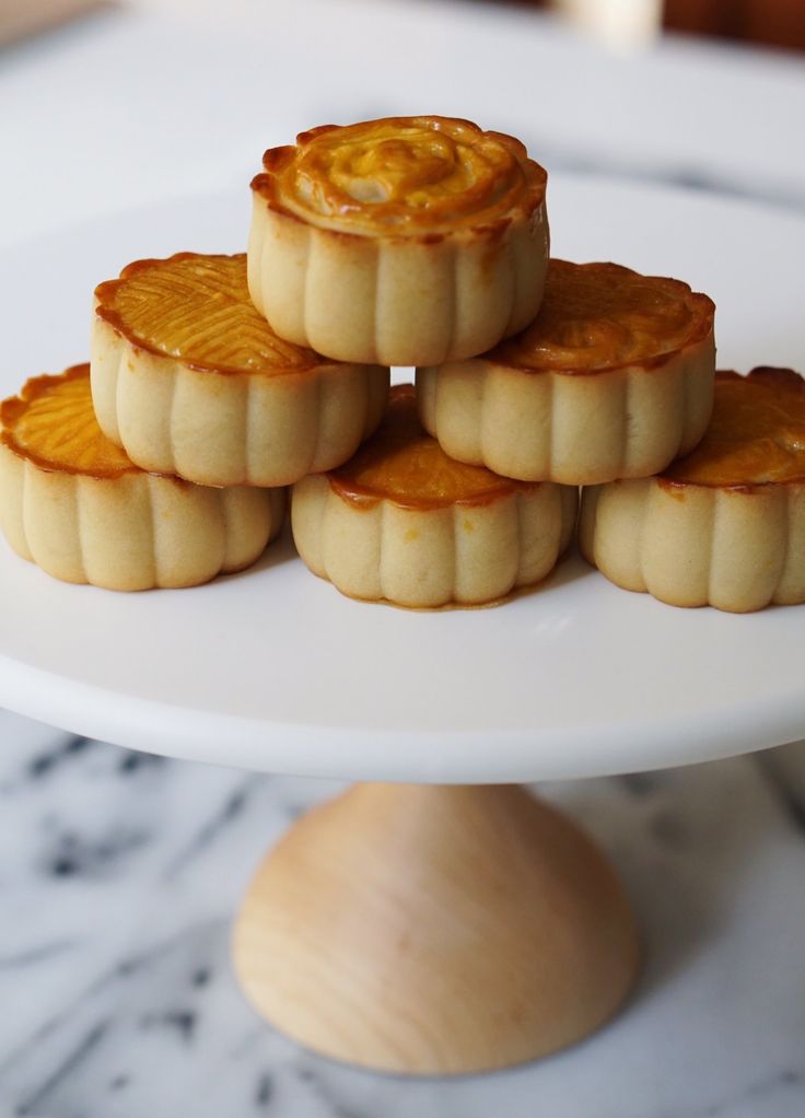 small desserts are stacked on top of each other on a white plate with a wooden stand