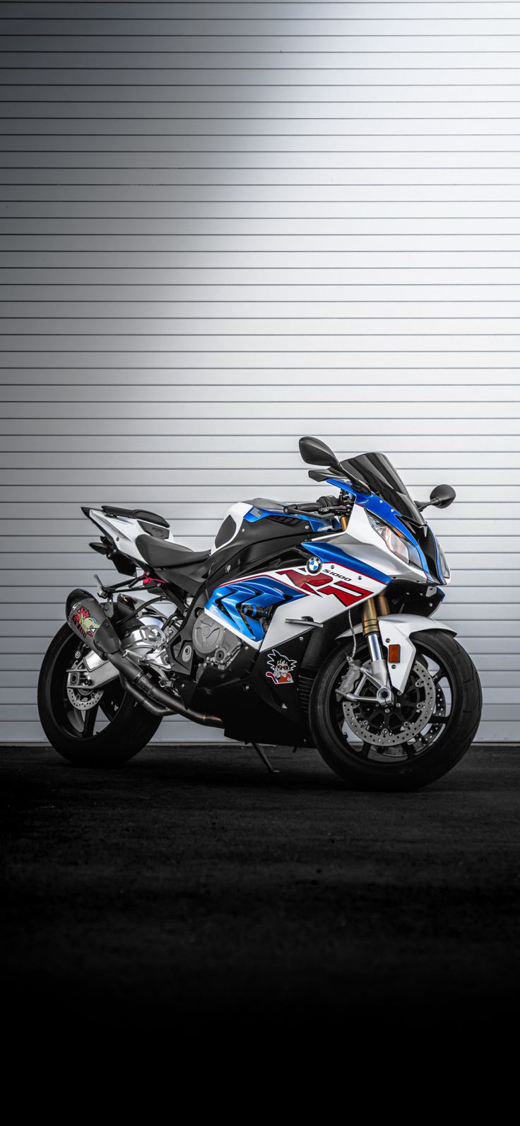 a white and blue motorcycle parked in front of a garage