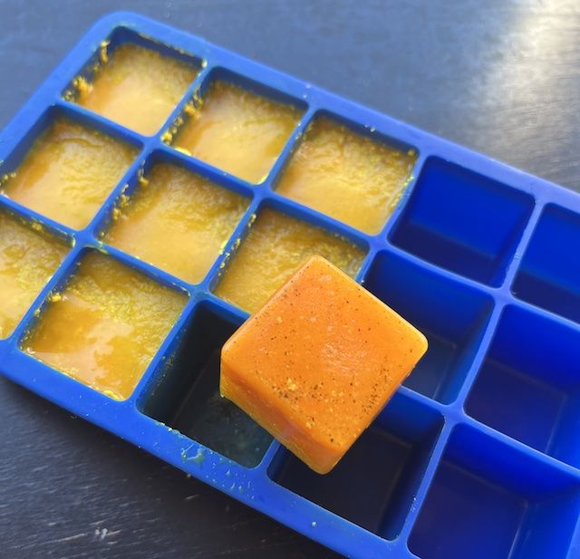 an ice tray filled with cubes of yellow liquid