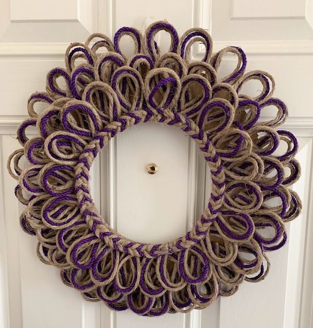 a purple and tan wreath hanging on the front door