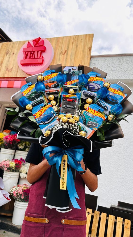 a man holding a large bouquet of candies in front of a store