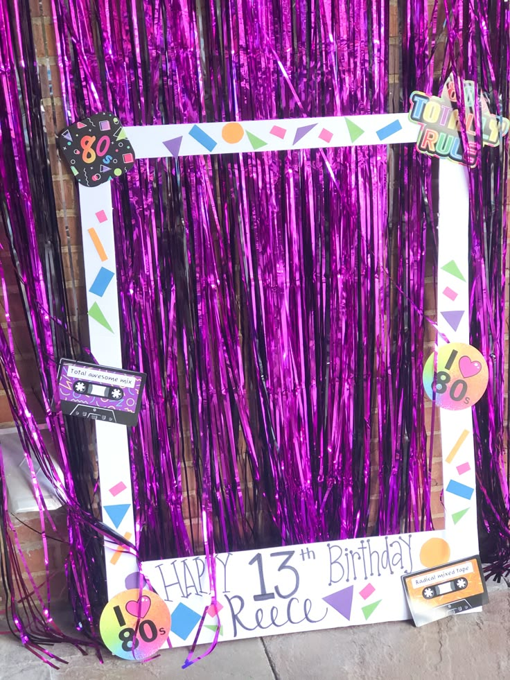 a birthday photo frame with purple tinsel and streamers