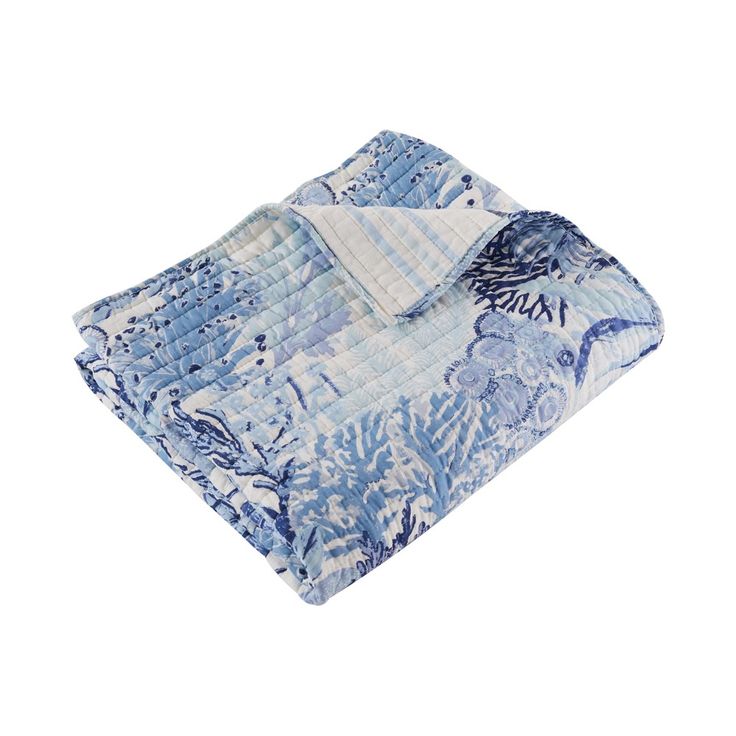 a blue and white floral print blanket on a white background