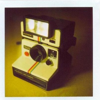 an old polaroid camera sitting on top of a table with the words volvere pronto - neas written below it