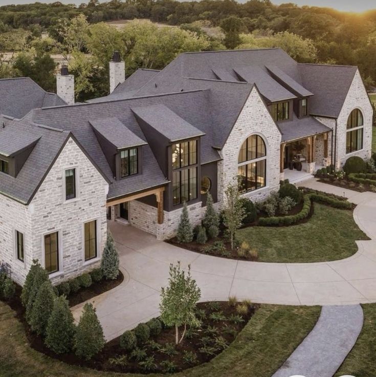 an aerial view of a large home with lots of windows and landscaping on the front lawn