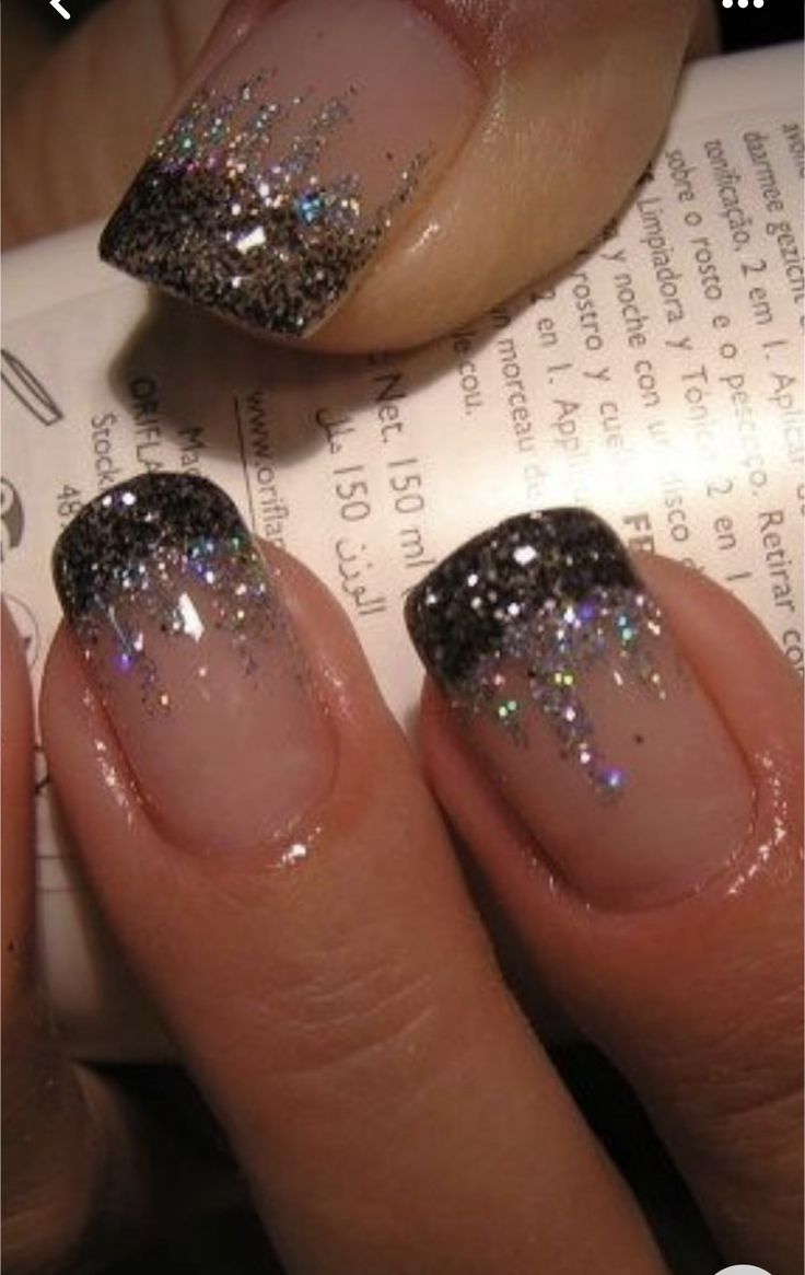 a woman's nails with glitter on them and an open book in the background