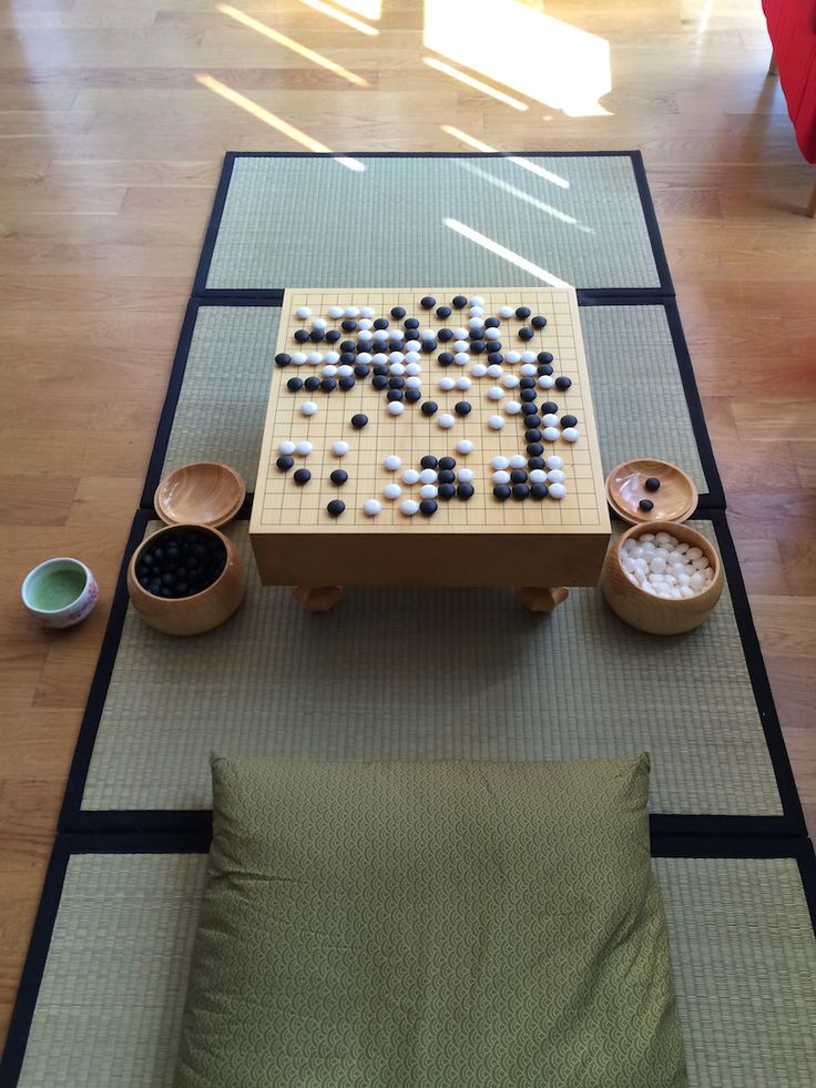 a table that has some cups and bowls on it with a board game in front of it