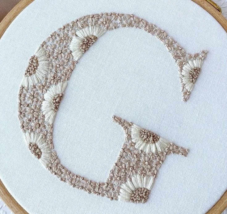 an embroidered letter q with flowers on it