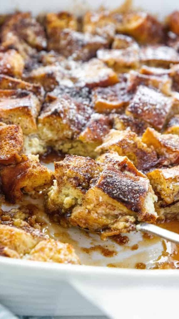 a casserole dish filled with french toast and caramel sauce in a white baking dish