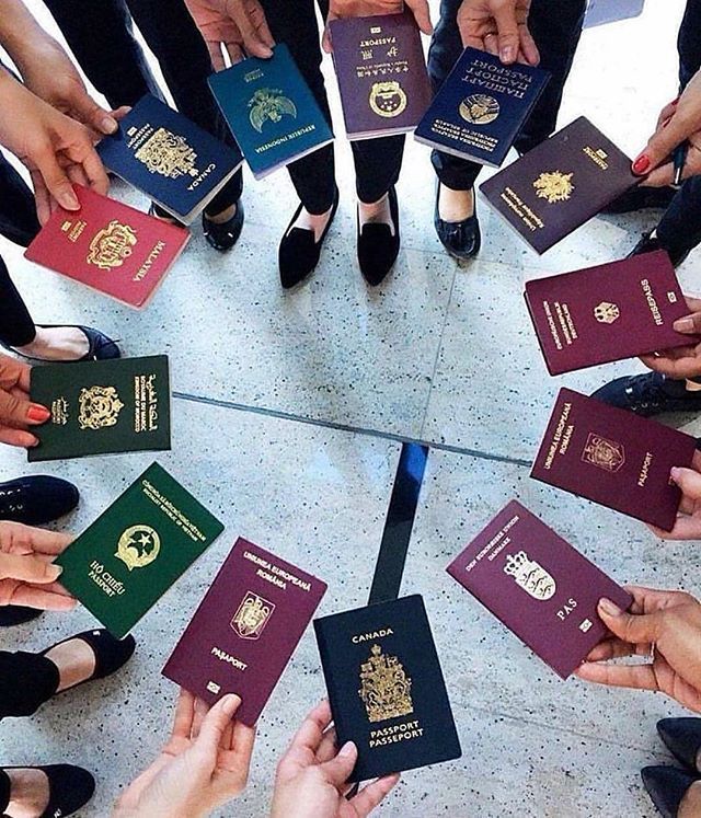 many people are holding their passports in a circle with one person's feet on the floor