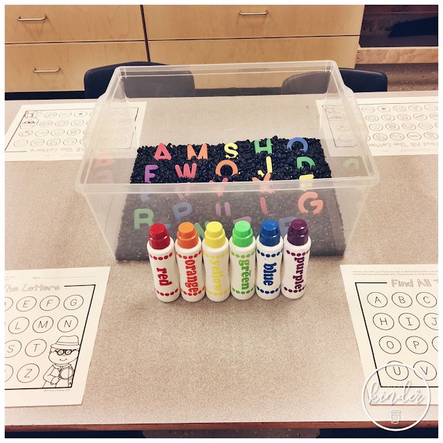 some crayons are sitting on the table with writing and markers in front of them