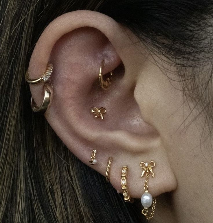 a close up of a person's ear with three different types of piercings