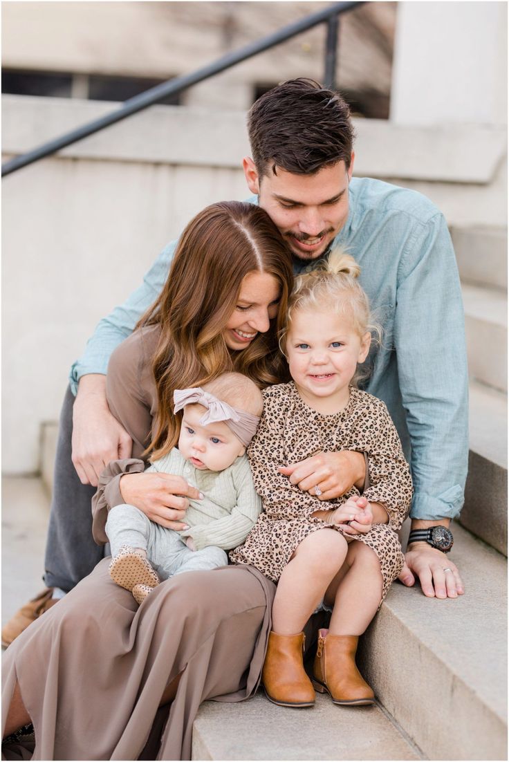 a man, woman and child sitting on the steps with their arms around each other