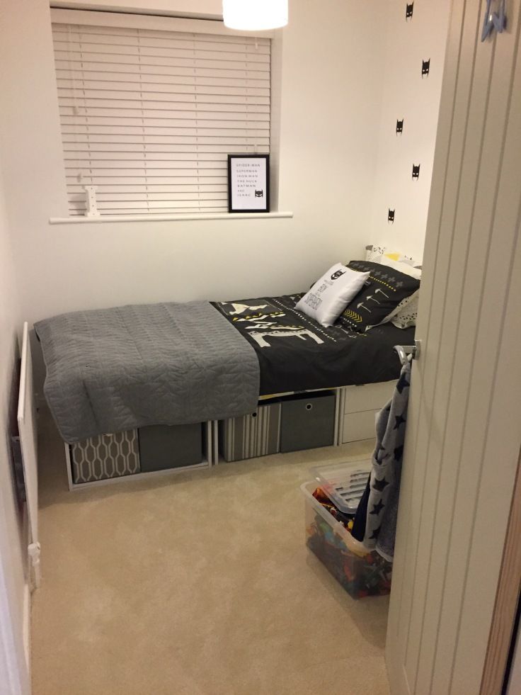 a small bedroom with a bed, dresser and window in it's center area