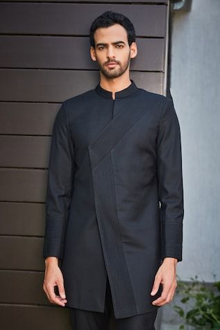 Black overlapped paneled, jacket style longline bandhgala with pintucked details on front. Comes with coordinating pant. - Aza Fashions Designer Tailored Kurta For Semi-formal Occasions, Designer Tailored Long Sleeve Kurta, Black Long Sleeve Designer Bandhgala, Tailored Long Sleeve Bandhgala For Designer Wear, Designer Long Sleeve Tailored Kurta, Designer Long Sleeve Kurta For Work, Fitted Black Kurta With Stand Collar, Designer Tailored Black Nehru Jacket, Designer Black Nehru Jacket With Long Sleeves