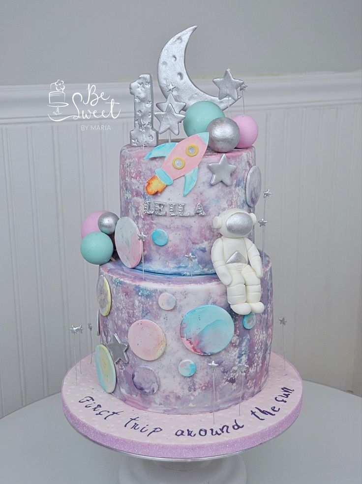 a three tiered cake decorated with space and stars