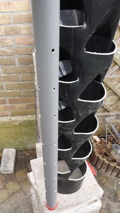 a traffic light sitting on top of a cement block next to a brick wall and sidewalk