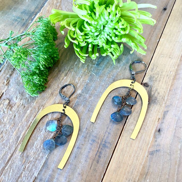 Coupled to perfection, these Bianca earrings are just the pop of playful you've been aching for. The horseshoe shaped pendants add a playful vibe to even the most monotone outfits. You will find yourself reaching for these playful earrings time and time again. The design is made of lightweight brass pendants and gorgeous labradorite gemstones on secure leverbacks. They offer plenty of unique interest while remaining neutral enough to pair with almost everything in your closet. Try adding them to Trendy Dangle Brass Earrings, Trendy Brass Dangle Earrings, Trendy Everyday Earrings With Dangling Charms, Trendy Dangling Charms Earrings For Everyday, Handmade Elegant Brass Earrings, Handmade White Brass Earrings, Unique Brass Earrings With Natural Stones, Hand-cast Brass Dangle Earrings, Patina Brass Dangle Earrings