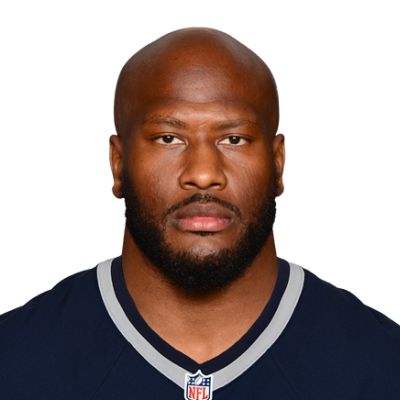 a close up of a person wearing a football uniform with a bald head and beard