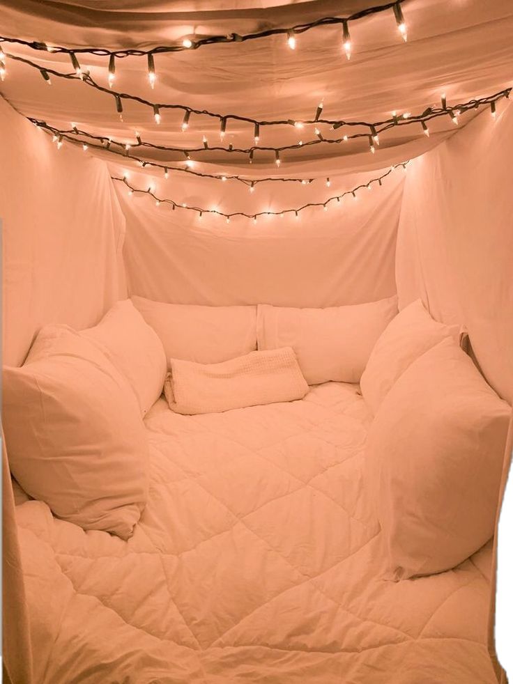 a bed that has some lights on the side of it and is covered in white sheets