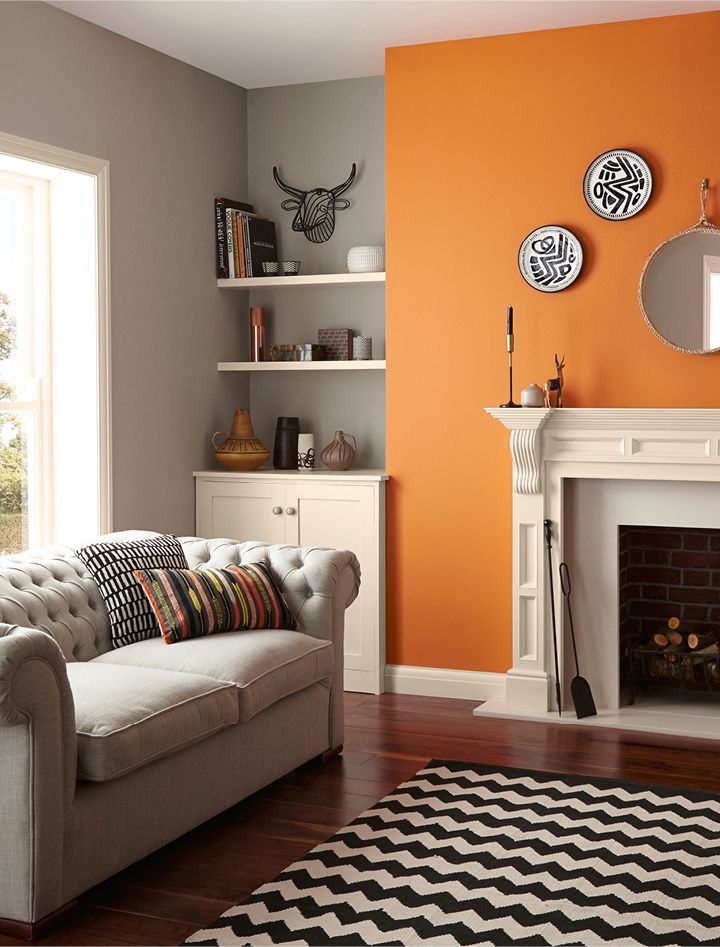 a living room filled with furniture and a fire place in front of a wall mounted clock