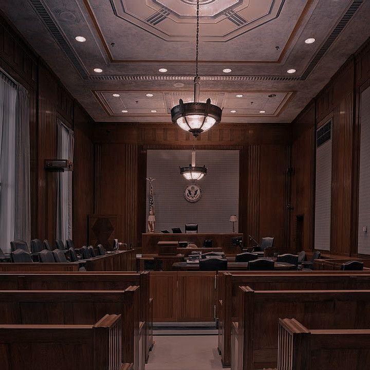 an empty courtroom with wooden benches and lights on the ceiling is seen in this image