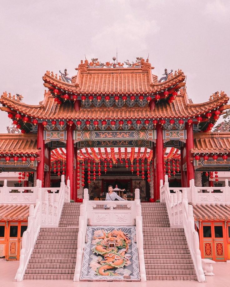 a man sitting on steps in front of a building with red and orange decorations around it