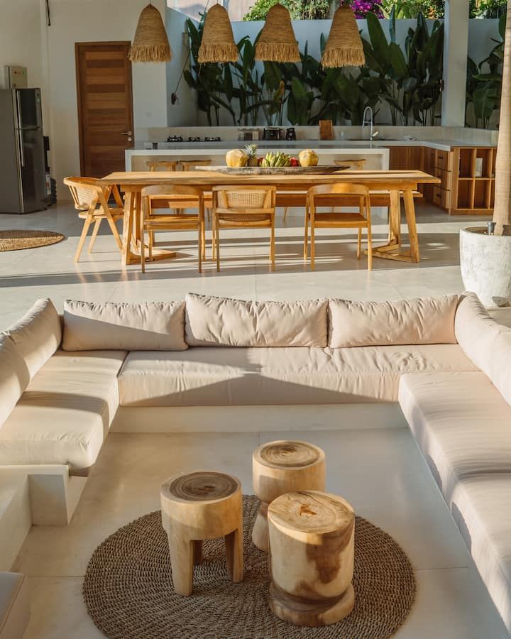 a living room filled with furniture next to a kitchen and dining room table in the background