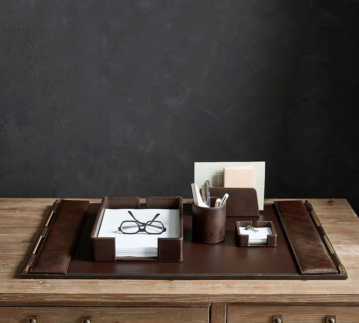 a wooden desk topped with a brown tray and glasses