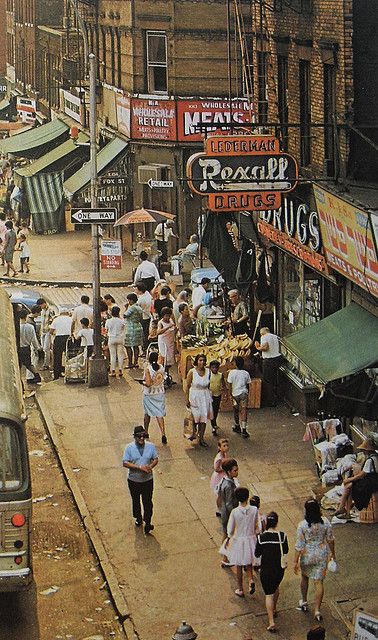 an old photo of people walking down the street