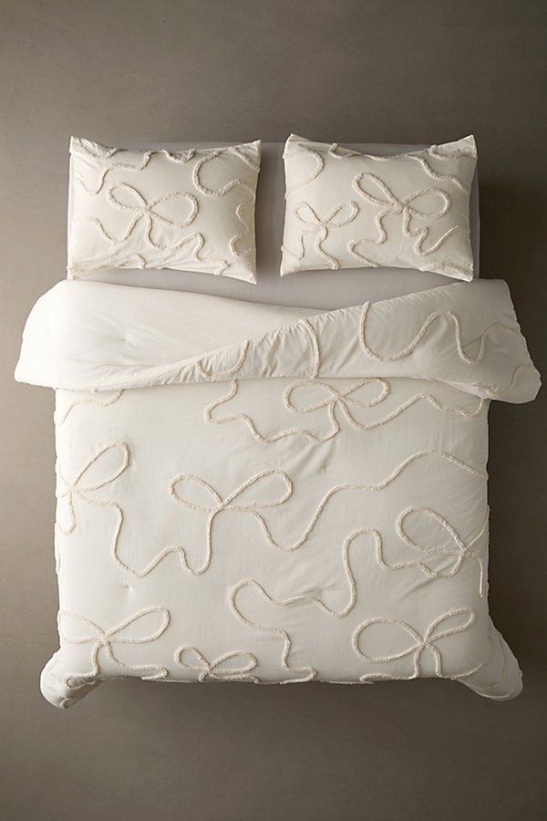 a white bed with two pillows on top of it