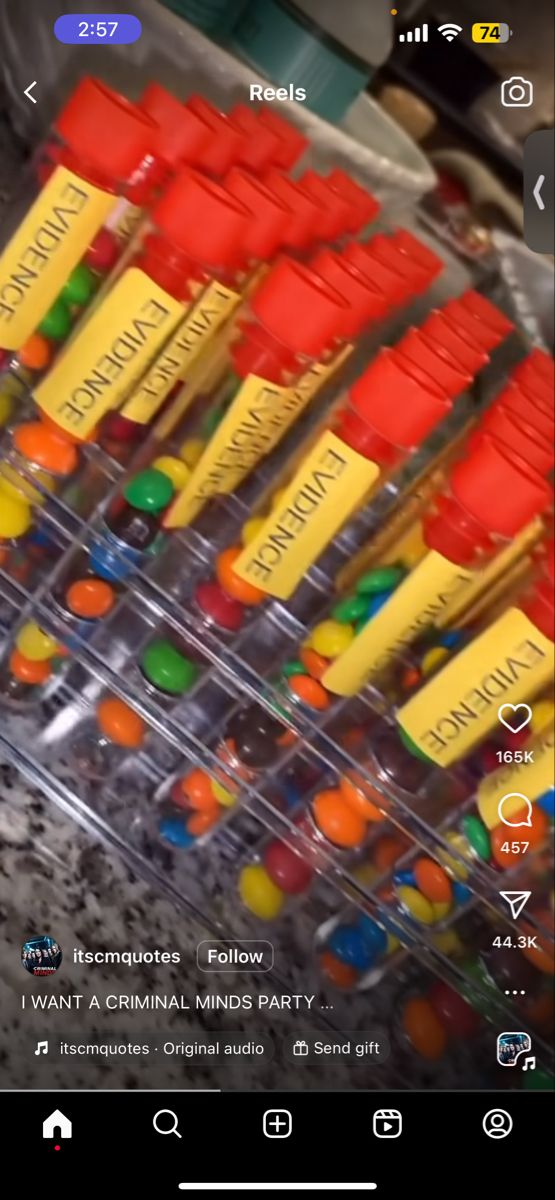 a bunch of orange, yellow and green candy sticks are in a plastic container with labels on them