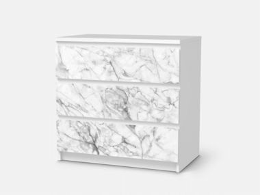 a white marble dresser with three drawers