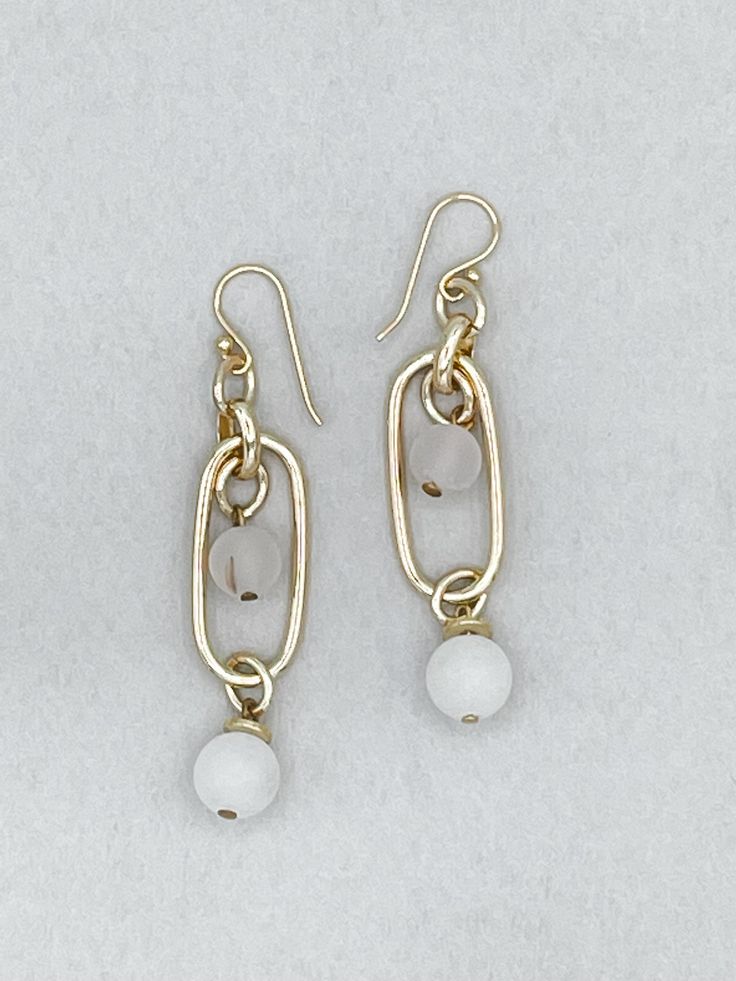 Featuring a beautiful white stone bead design, these Zephyr Chain Earrings offer classic elegance with a modern touch. Whether you are looking for a subtle addition to an evening look, or a casual piece to add to your day-to-day wardrobe, these earrings are a perfect choice. Crafted with quality sterling silver, these earrings are sure to be a timeless addition to your jewelry collection. Details: Dangle Earring Paperclip Chain Link Cloud White Stone Beads Handmade French Hook Ear Wire Approxima Elegant Beaded Chain Drop Earrings, Elegant Beaded Chain Earrings, Elegant Round Beaded Metal Earrings, Elegant Beaded Chain Dangle Earrings, Elegant Metal Beaded Earrings With Round Beads, White Beaded Chain Earrings, Elegant White Beaded Chain Earrings, Metal Drop Earrings With Beaded Chain, Elegant Adjustable Beaded Earrings