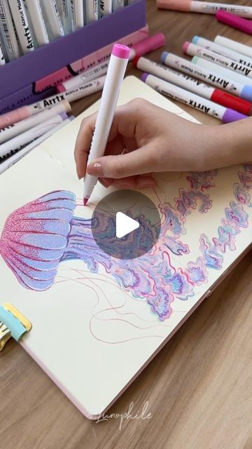 a person is drawing with colored pencils on a book