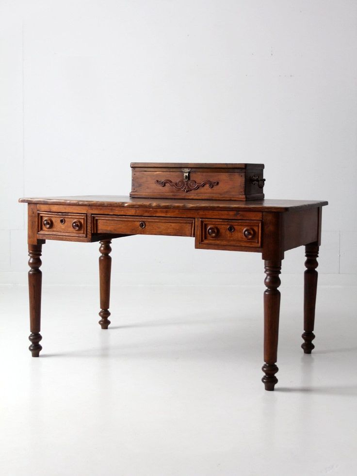 an old wooden desk with drawers and a book on top, against a white background