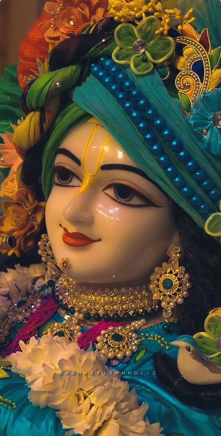 a close up of a statue of a person with flowers in her hair and an elaborate headdress