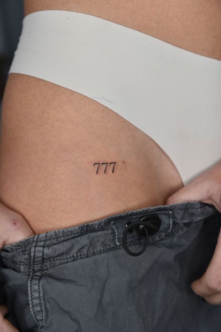 a woman's stomach with the word pi on it, and an arrow tattoo