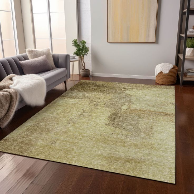 a living room area with a couch, chair and rug on the hardwood flooring