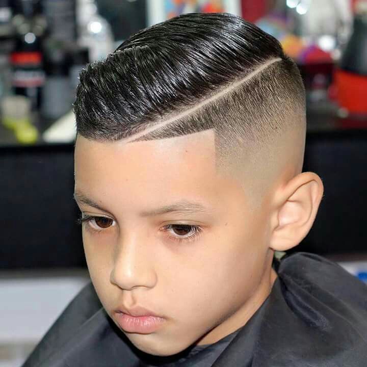 a young boy in a barbershop getting his hair cut