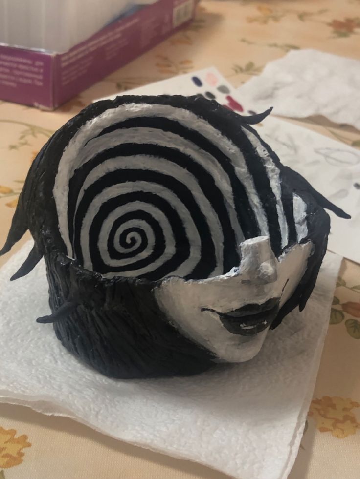 a black and white mask on top of a napkin