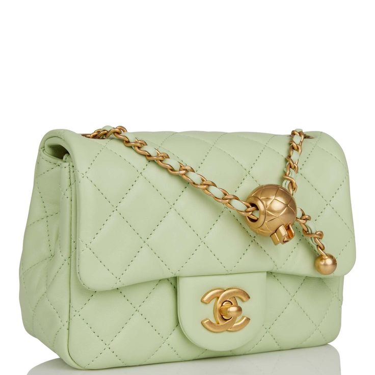 This Pearl Crush Mini Square flap bag is of light green lambskin with antique gold tone hardware and has a front flap with signature CC turnlock closure, rear half moon pocket, single interwoven light green leather and antique gold tone chain link shoulder/crossbody strap with adjustable "pearl" ball. The interior is lined in light green leather and features a zipper pocket with Chanel pull and an open pocket below. Collection: 22C Origin: Italy Condition: Pristine; new or never Accompanied by: Chanel Pearl Crush, Chanel Green, Chanel Pearl, Chanel Box, Chanel Pearls, Chanel Mini, Gold Bag, Bag Light, Womens Purses