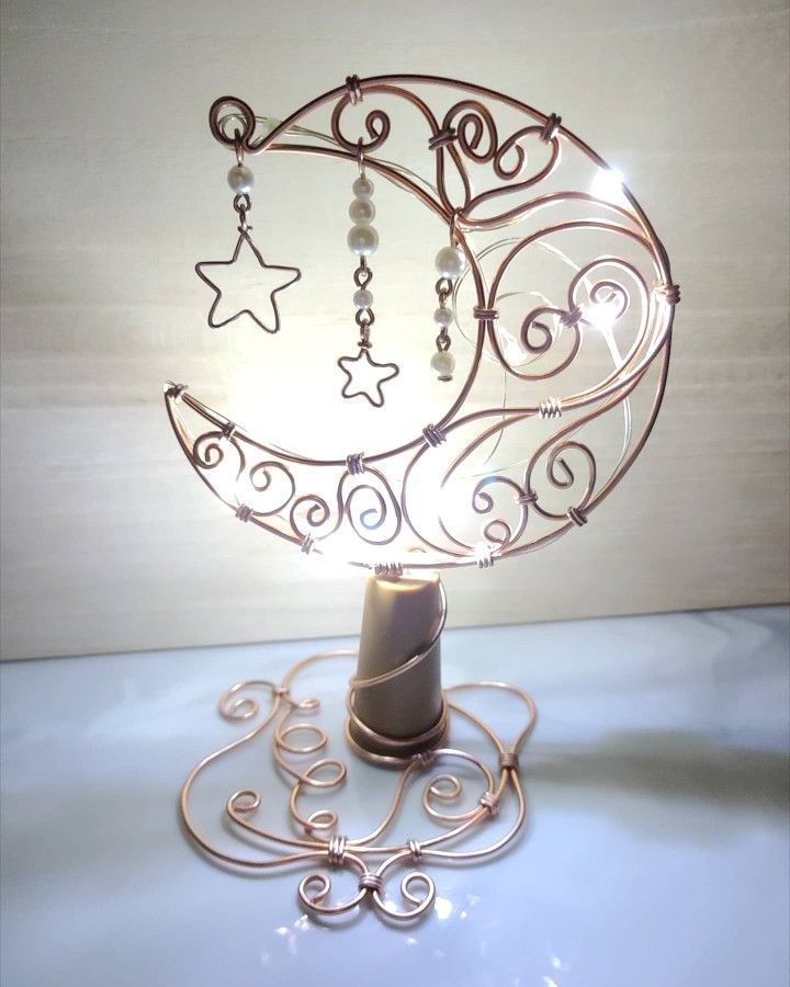 a small lamp that is on top of a blue table with beads and stars hanging from it