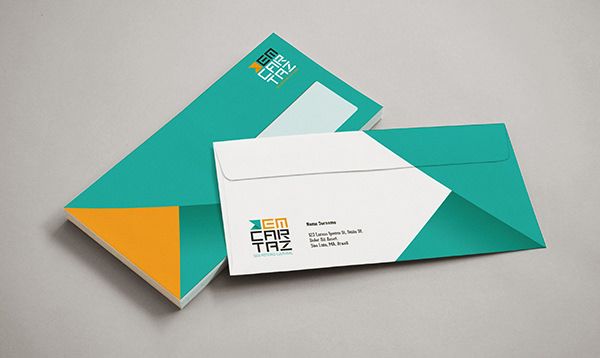 two envelopes with business cards on them sitting next to each other in front of a gray background