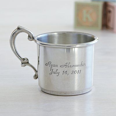 a small silver cup with the date and year engraved on it, sitting on a table