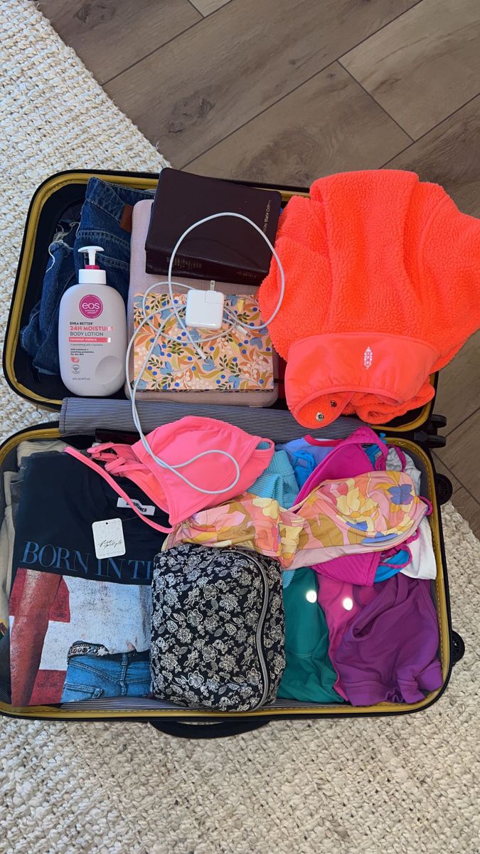 an open suitcase filled with clothes on the floor